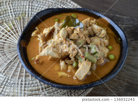 A Panang curry with chicken, long beans, turkey berries, and kaffir lime leaves is served in a ceramic bowl. A Panang curry with chicken, long beans, turkey berries, and kaffir lime leaves is served in a ceramic bowl. 136032243