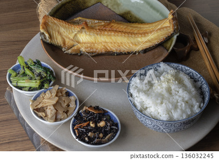 A traditional Japanese teishoku set meal features a large, golden-brown charcoal-grilled Atka mackerel, also known as Shima Hokke. 136032245