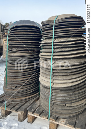 The raw material for recycling is rubber in the form of circles. The cut-out parts of the tires are in stacks. hdpe waste is low-pressure polythylene. High quality photo 136032375