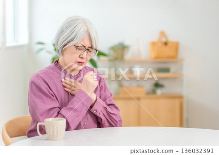 一位頭髮花白的老婦人患有咳嗽、氣喘、肺炎和支氣管炎。 一位頭髮花白的老婦人患有咳嗽、氣喘、肺炎和支氣管炎。 136032391