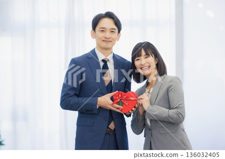 A woman giving a gift to a man in the office 136032405