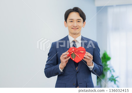 A woman giving a gift to a man in the office A woman giving a gift to a man in the office 136032415
