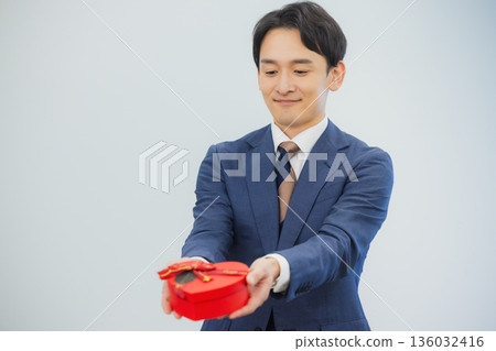 A woman giving a gift to a man in the office A woman giving a gift to a man in the office 136032416