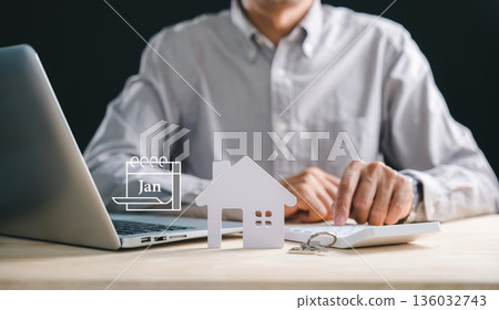 Financial planning for home investment involves man calculating money using calculator, property model, and laptop, displaying January calendar for future finance plan, showing mortgage loan Financial planning for home investment involves man calculating money using calculator, property model, and laptop, displaying January calendar for future finance plan, showing mortgage loan 136032743