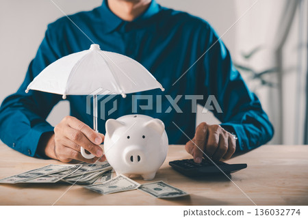 protect money in piggy bank, financial insurance risk umbrella finance collage concept shows businessman holding white umbrella over dollars using calculator for safety planning protect money in piggy bank, financial insurance risk umbrella finance collage concept shows businessman holding white umbrella over dollars using calculator for safety planning 136032774