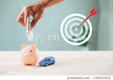 economy money finance global growth market piggy bank financial invest strategy shows hand putting dollar bill inside coin slot near blue toy car under target icon with red arrow economy money finance global growth market piggy bank financial invest strategy shows hand putting dollar bill inside coin slot near blue toy car under target icon with red arrow 136032828