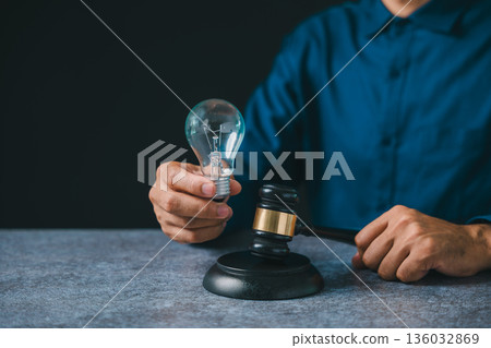 Legal expert holding light bulb near gavel to protect patent intellectual property law, business idea concept protection ensures rights for creative innovation in modern office Legal expert holding light bulb near gavel to protect patent intellectual property law, business idea concept protection ensures rights for creative innovation in modern office 136032869