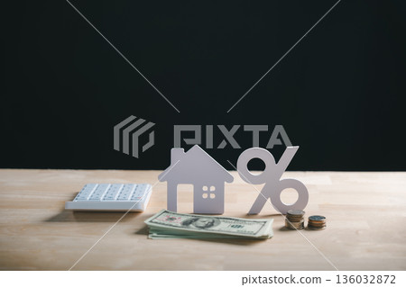 House model, percent sign, money, coins and calculator show home property financing, mortgage loan interest rate calculation, real estate investment 136032872