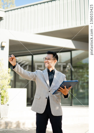 Focused businessman planning new goals and writing business ideas in notebook outdoors, symbolizing motivation, success, and fresh start in professional life. Focused businessman planning new goals and writing business ideas in notebook outdoors, symbolizing motivation, success, and fresh start in professional life. 136033425