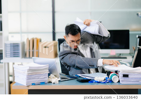 Focused office worker analyzing documents, reviewing business reports with stress and concentration in workplace setting. Focused office worker analyzing documents, reviewing business reports with stress and concentration in workplace setting. 136033640