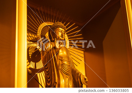 The Buddha statue standing with the light behind it symbolizes guidance and spirituality The Buddha statue standing with the light behind it symbolizes guidance and spirituality 136033805