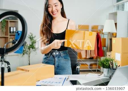 Fashion blogger concept, Young Asian women selling clothes on video streaming.Startup small business SME, using smartphone or tablet taking receive and checking Fashion blogger concept, Young Asian women selling clothes on video streaming.Startup small business SME, using smartphone or tablet taking receive and checking 136033907