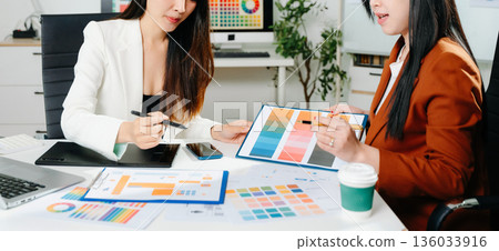 Creative female designers team using pen tablet and color palette working in graphic design Choose colors for working on tablets and computer designs. Creative female designers team using pen tablet and color palette working in graphic design Choose colors for working on tablets and computer designs. 136033916