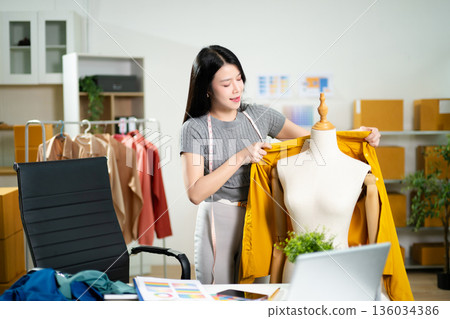 Fashion designer presenting apparel on mannequin with color palette in a studio. Creative styling process, garment development, textile planning 136034386