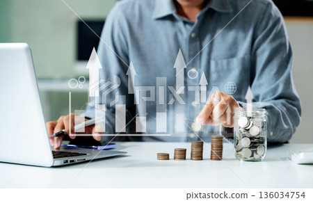 saving money with hand putting coins in jug glass and calculator to calculate budget concept finance and accounting saving money with hand putting coins in jug glass and calculator to calculate budget concept finance and accounting 136034754