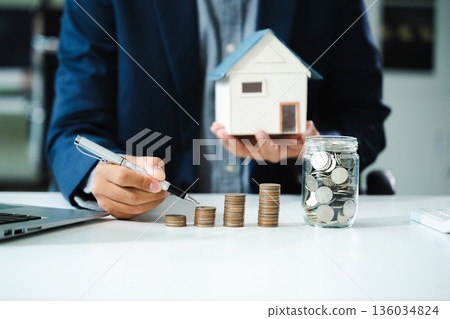 businessman holding coins putting in glass with using smartphone and calculator to calculate concept saving money businessman holding coins putting in glass with using smartphone and calculator to calculate concept saving money 136034824