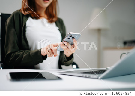 Confident businessman working on laptop, tablet and smartphone at her workplace 136034854