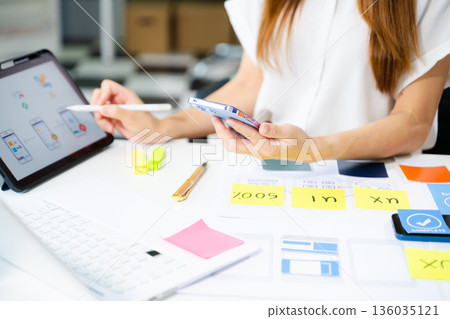 UI developer team brainstorming on their project with laptop, smartphone and digital tablet. Creative digital development agency UI developer team brainstorming on their project with laptop, smartphone and digital tablet. Creative digital development agency 136035121