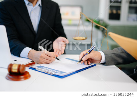 Business meeting with lawyer and client signing contract, calculator and gavel on desk. Perfect for finance, legal, Business meeting with lawyer and client signing contract, calculator and gavel on desk. Perfect for finance, legal, 136035244