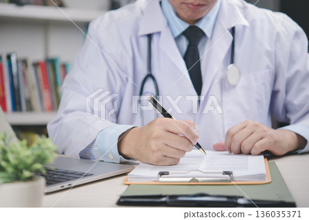 Doctor in white coat signing medical agreement on desk, confirming approval, patient data record, healthcare validation, legal documentation, official certification, hospital paperwork. 136035371