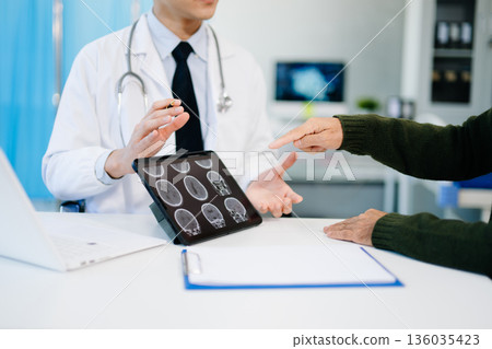 Doctor showing brain scans with AI health data overlay, symbolizing innovation, digital healthcare, and future medical technology consultation. 136035423