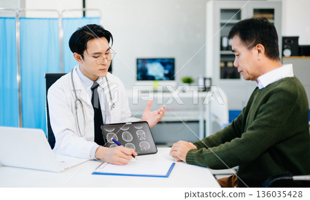 Doctor showing brain MRI results to patient during consultation in modern clinic. Perfect for healthcare, diagnosis, neurology, or medical treatment themes. 136035428