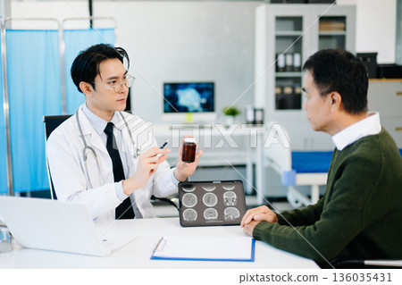 Doctor discussing brain MRI results and medication with patient during medical consultation. Perfect for healthcare, diagnosis 136035431