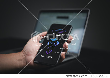 Smartphone AI translation app for global communication. A person holds a digital device displaying various languages, digital transformation, and the technology of machine learning Smartphone AI translation app for global communication. A person holds a digital device displaying various languages, digital transformation, and the technology of machine learning 136035462