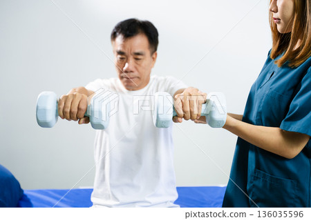 Female physiotherapist supports arm movement exercise for senior male patient during rehabilitation. Elderly care 136035596