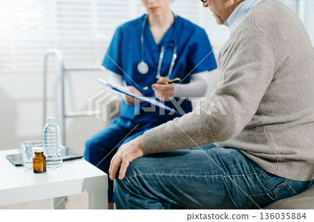 Senior man with chest pain speaks to nurse noting symptoms on tablet at home. Healthcare, heart health Senior man with chest pain speaks to nurse noting symptoms on tablet at home. Healthcare, heart health 136035884