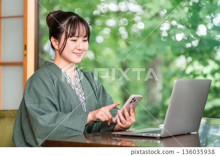 一位身穿浴衣的女子在溫泉旅館的房間使用電腦 136035938
