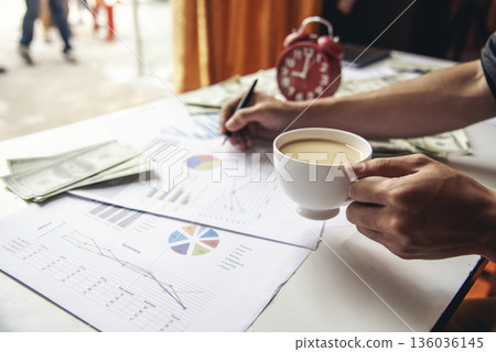Businesswoman reading financial graph charts Planning analyzing marketing data. Women hands using smartphone, laptop on office desk. Hands of young asian woman working in office firm business info. Businesswoman reading financial graph charts Planning analyzing marketing data. Women hands using smartphone, laptop on office desk. Hands of young asian woman working in office firm business info. 136036145