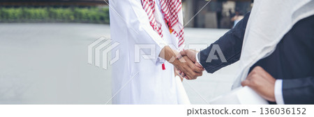 Banner Arab Businessman shaking hands together. Teamwork business partner wear Muslim dress Shake Hands partnership. Banner Success UAE diversity people trust commitment handshake with copy space 136036152