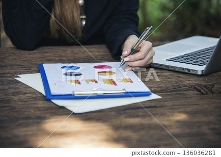 Woman working business office desk using laptop work from home. Businesswoman looking financial business chart, graph, infographic analyze sale statistics. Woman hands on entrepreneur office desk Woman working business office desk using laptop work from home. Businesswoman looking financial business chart, graph, infographic analyze sale statistics. Woman hands on entrepreneur office desk 136036281