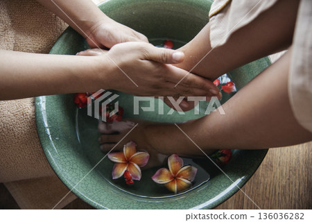 Massage Thai Spa foot massage flower oil therapy. Close up woman foot therapy relax treatment Aromatherapy salon. Spa legs relaxation muscle relief. Woman happy relax skin Foots Soak spa oil wellness 136036282