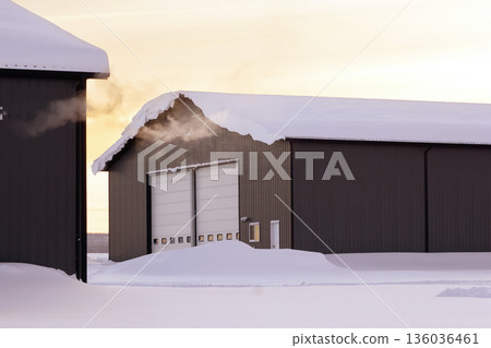 Steam from heater in industrial building in sunset time in winter. Steam from heater in industrial building in sunset time in winter. 136036461