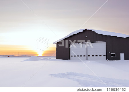 Warehouse in snow, industrial building in sunset light in winter. Warehouse in snow, industrial building in sunset light in winter. 136036462