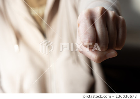 Woman's hand with a clenched fist Woman's hand with a clenched fist 136036678