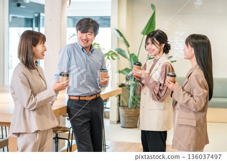 Businessman and businesswoman chatting over coffee in the office Businessman and businesswoman chatting over coffee in the office 136037497