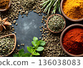 Spices and herbs arranged artistically on a dark stone surface with various textures and colors enhancing culinary creativity 136038083