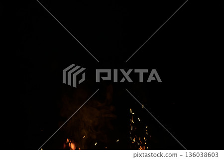 Sparks from campfire over dark background in the night 136038603