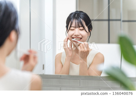 Young Asian woman suffering from tooth decay, tooth sensitivity and periodontal disease after brushing her teeth 136040076