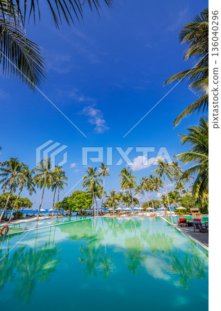 Vertical sunny playful tropical infinity pool beach resort palm loungers turquoise sea horizon summer happy relaxation paradise 136040296