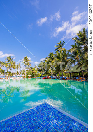 Vertical happy luxury beach resort infinity pool with palm trees sun loungers turquoise water summer fun relaxation vibes 136040297