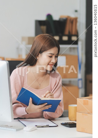 Starting small businesses SME owners female entrepreneurs check online orders to prepare to pack the boxes, sell to customers, sme business ideas online. Starting small businesses SME owners female entrepreneurs check online orders to prepare to pack the boxes, sell to customers, sme business ideas online. 136040815