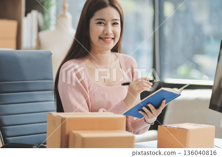 Starting small businesses SME owners female entrepreneurs check online orders to prepare to pack the boxes, sell to customers, sme business ideas online. Starting small businesses SME owners female entrepreneurs check online orders to prepare to pack the boxes, sell to customers, sme business ideas online. 136040816