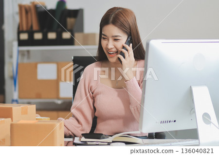 Starting small businesses SME owners female entrepreneurs check online orders to prepare to pack the boxes, sell to customers, sme business ideas online. Starting small businesses SME owners female entrepreneurs check online orders to prepare to pack the boxes, sell to customers, sme business ideas online. 136040821