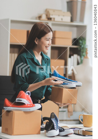 Starting small businesses SME owners female entrepreneurs check online orders to prepare to pack the boxes, sell to customers, sme business ideas online. 136040843