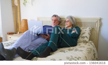 Senior couple in bed watching laptop together 136041618