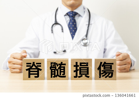A block with the words "Spinal Cord Injury" written on it and a doctor A block with the words "Spinal Cord Injury" written on it and a doctor 136041661